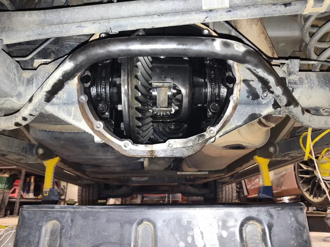 The underside of a truck with the rear differential cover off, showing the ring gear.